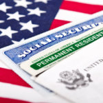 Green card and social security card on top of American flag