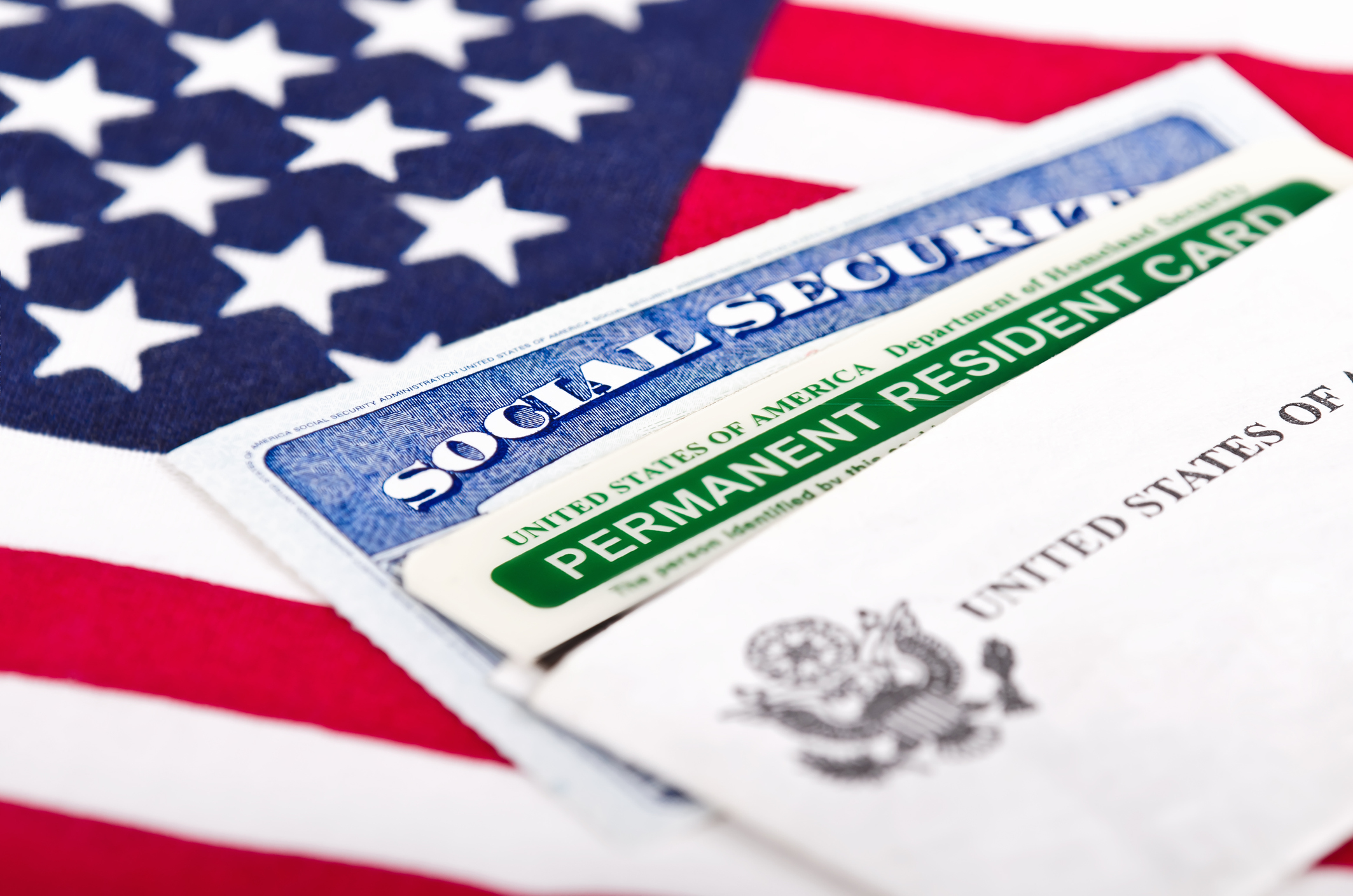 Green card and social security card on top of American flag